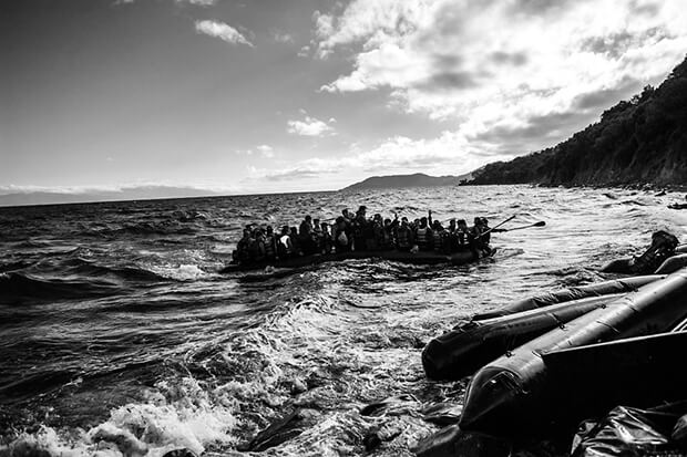 Migrants arrive on a dinghy after crossing from Turkey to Lesbos. Greece has been overwhelmed this year by record numbers of migrants. More than 250,000 people have reached Greece so far this year, the vast majority of them Syrians or Afghans fleeing conflict.